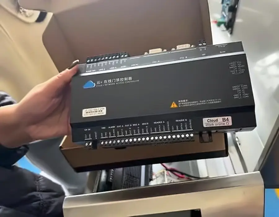 The industrial gate controller, held in a hand