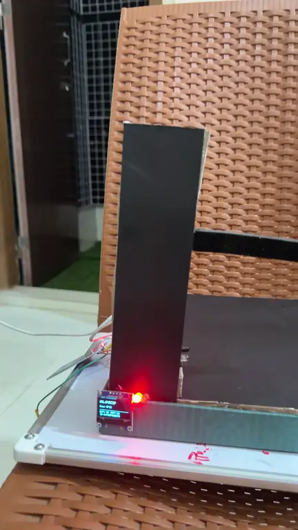 The real cardboard prototype in December 2025: a card is tapped, the light turns green and the arm lifts