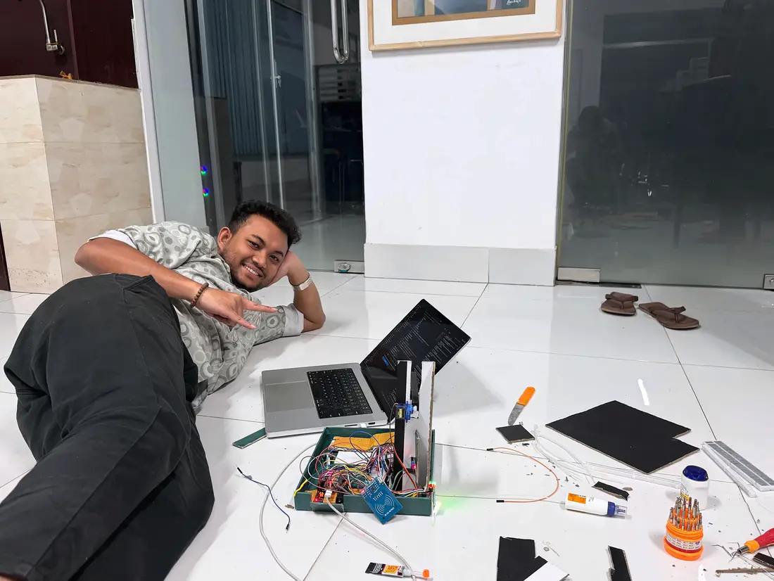 Nowshid Alam Sayem on the office floor next to the working cardboard prototype of the gate