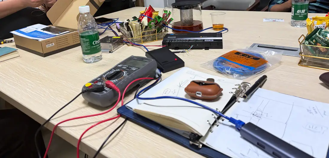 Testing the gate hardware with a multimeter and power supply at the factory in Shenzhen